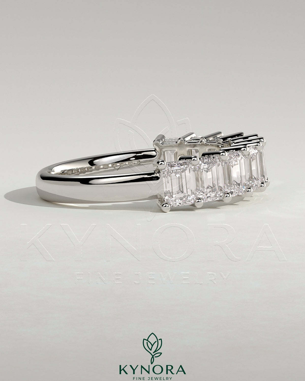 Emerald eternity band wedding ring by Kynora CJ featuring a continuous row of emerald gemstones in a sleek gold setting.