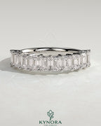 Elegant emerald eternity band wedding ring by Kynora CJ, featuring continuous emerald gemstones on a sleek gold band.