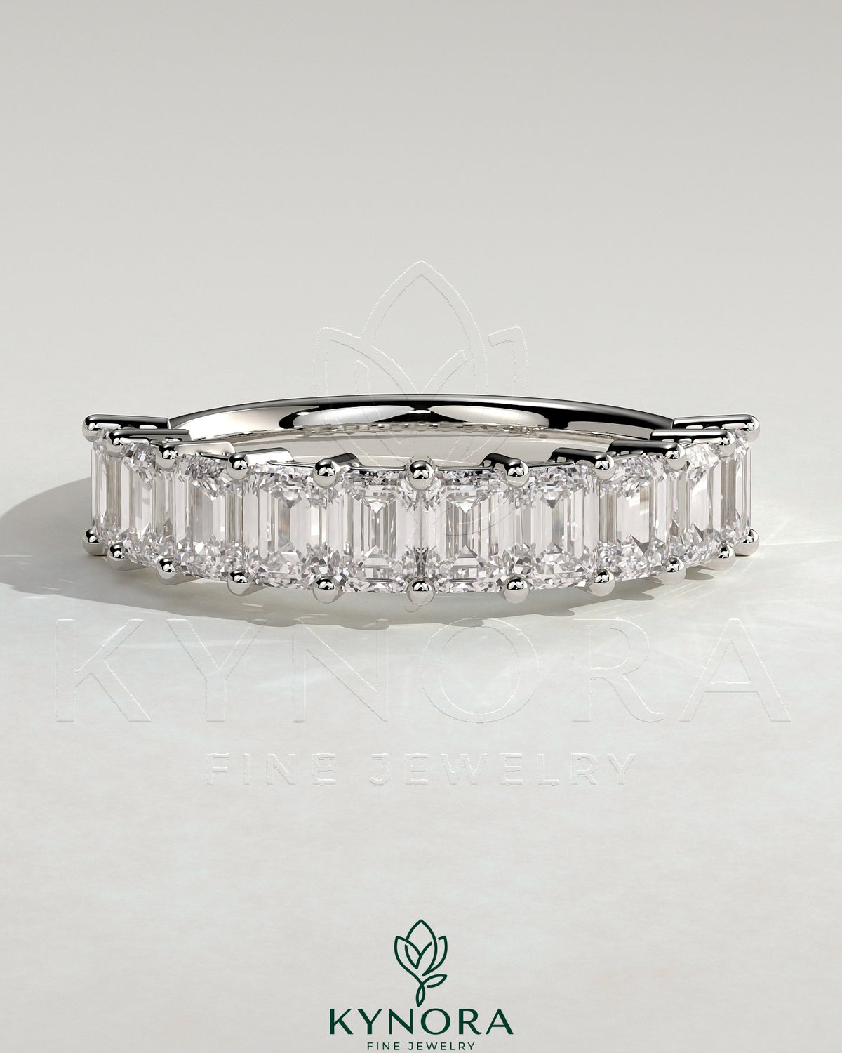 Elegant emerald eternity band wedding ring by Kynora CJ, featuring continuous emerald gemstones on a sleek gold band.