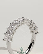 Emerald eternity band wedding ring by Kynora CJ featuring numerous emerald gemstones in a continuous design.