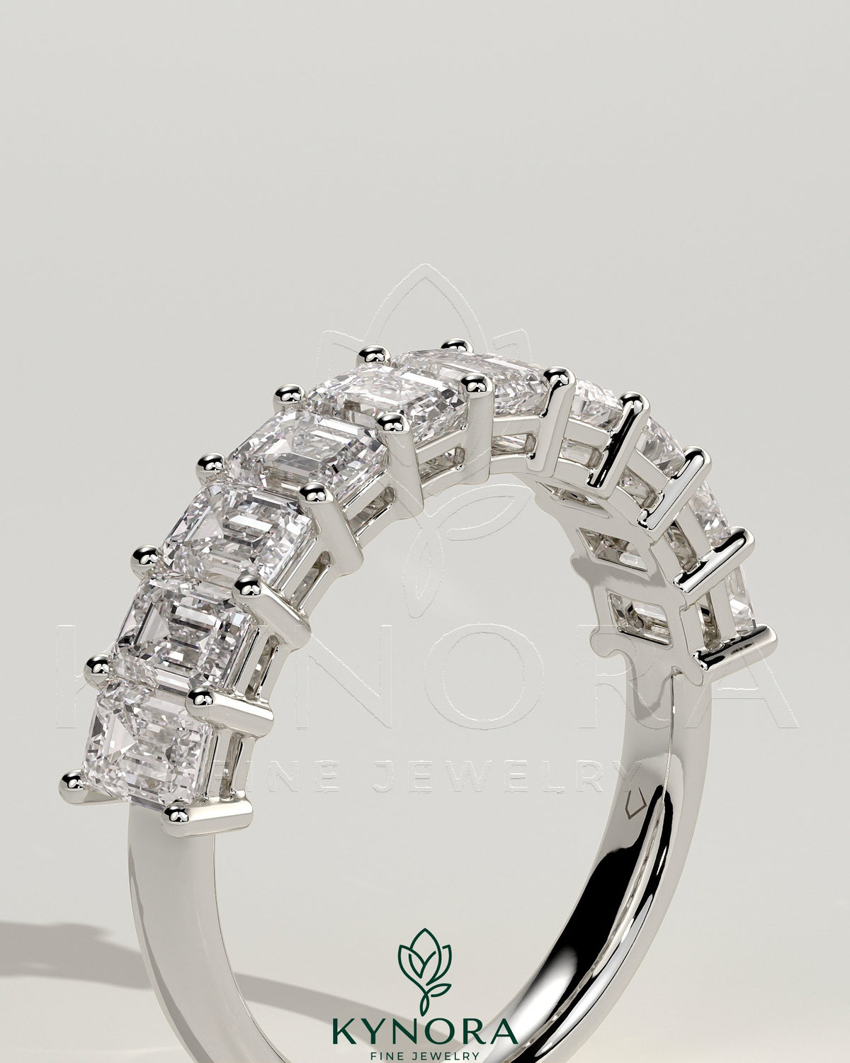 Emerald eternity band wedding ring by Kynora CJ featuring numerous emerald gemstones in a continuous design.