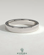 Kynora CJ flat cigar band wedding ring in polished gold, showcasing a sleek, wide design suitable for wedding jewelry.