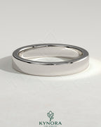 Kynora CJ flat cigar band wedding ring with a smooth, matte finish in gold, showcasing a simple, elegant design.