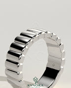 Kynora CJ fluted wedding band featuring a sleek, rounded cigar-style design in polished metal for a sophisticated look.