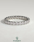 Kynora CJ full round eternity wedding band with scalloped setting, featuring intricate design and sparkling gemstones.