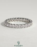 Kynora CJ full round eternity wedding band with scalloped setting in polished gold, showcasing intricate design and sparkling gemstones.