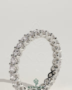 Full round eternity wedding band with scalloped setting by Kynora CJ, featuring a continuous circle of sparkling gemstones.