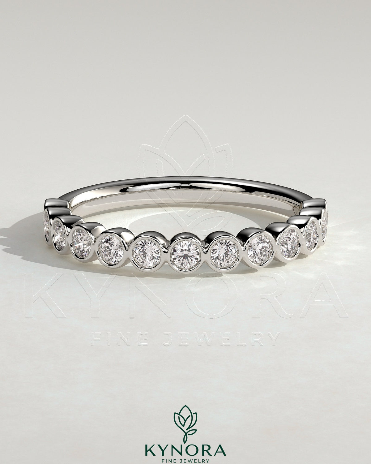 Kynora CJ half eternity round bezel set wedding band with sparkling gemstones, elegant and timeless jewelry for special occasions.