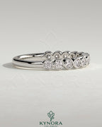 Kynora CJ half eternity wedding band with round bezel-set diamonds, elegant gold wedding ring for special occasions.
