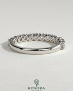 Kynora CJ half round eternity wedding band with scalloped setting, crafted in polished metal, featuring a continuous circle of gemstones.