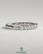 Elegant half round eternity wedding band with scalloped setting by Kynora CJ, showcasing intricate design and sparkling gemstones.