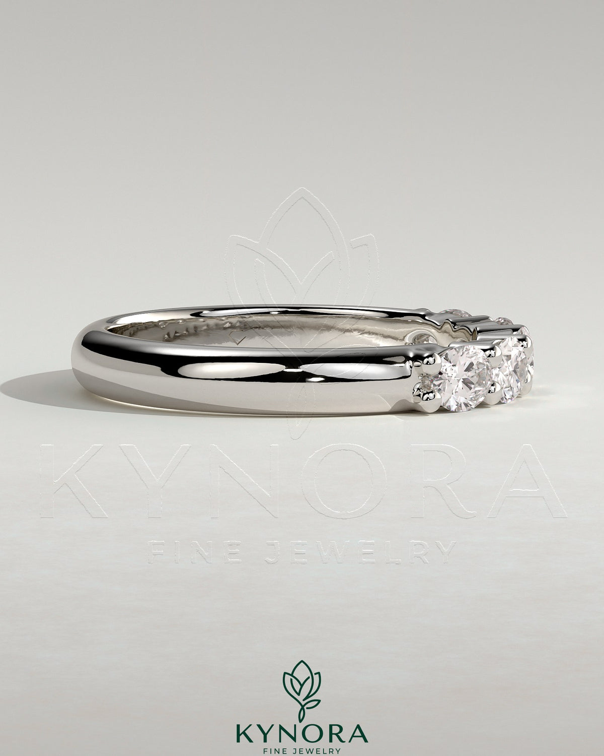 Sterling silver wedding band with oval east-west moissanite accent stone in a closed basket setting by Kynora CJ