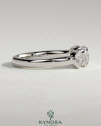 Oval bezel set wedding ring by Kynora CJ, featuring a sleek band with an elegant oval gemstone setting.