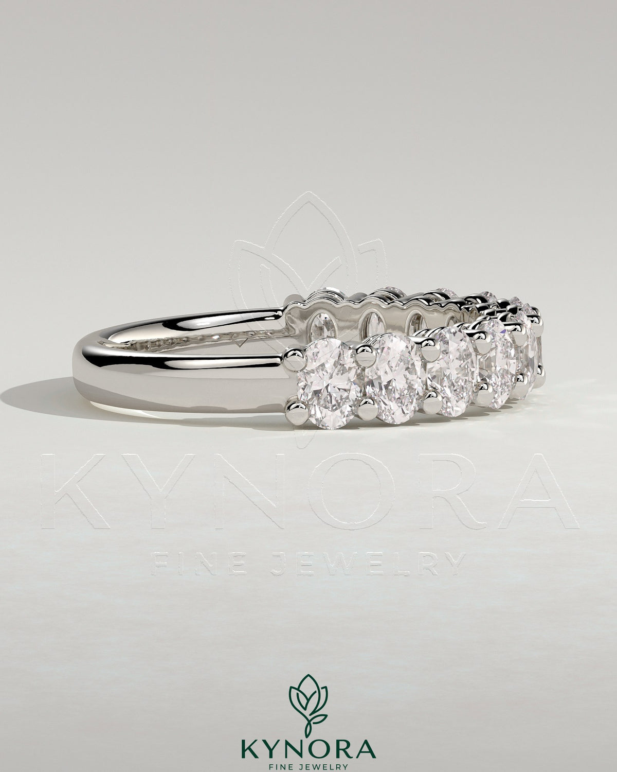 Kynora CJ oval eternity wedding band with sparkling gemstone accents, elegant design for special occasions.