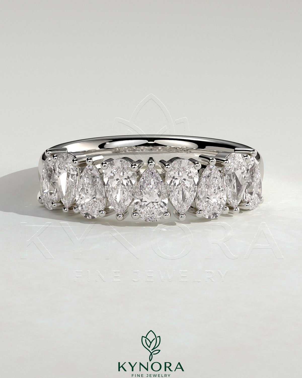 Kynora CJ Pear alternating half eternity wedding band with closed basket setting, featuring sparkling pear-shaped gemstones.