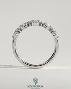 Kynora CJ Pear alternating half eternity wedding band with closed basket setting, featuring sparkling gemstones in a delicate design.