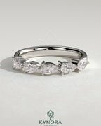 Kynora CJ Pear East West Accent Stone wedding band with closed basket setting, showcasing sparkling gemstones in a elegant gold ring.