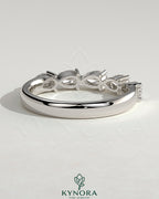Kynora CJ Pear East West Accent Stone wedding band with closed basket setting, elegant silver-tone wedding ring design.