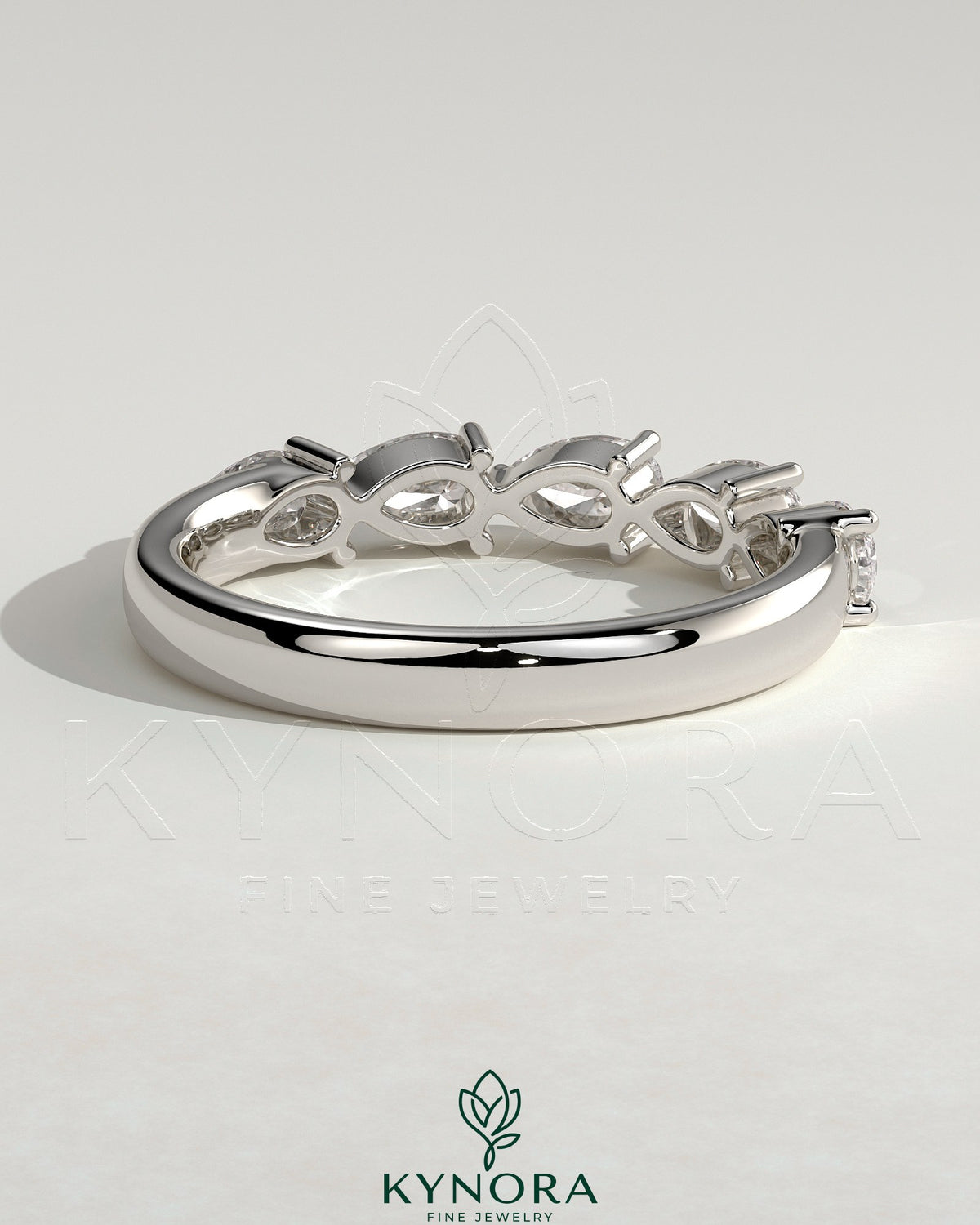 Kynora CJ Pear East West Accent Stone wedding band with closed basket setting, elegant silver-tone wedding ring design.