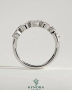 Kynora CJ Pear East West Accent Stone wedding band with closed basket setting, featuring a pear-shaped gemstone in elegant jewelry design.