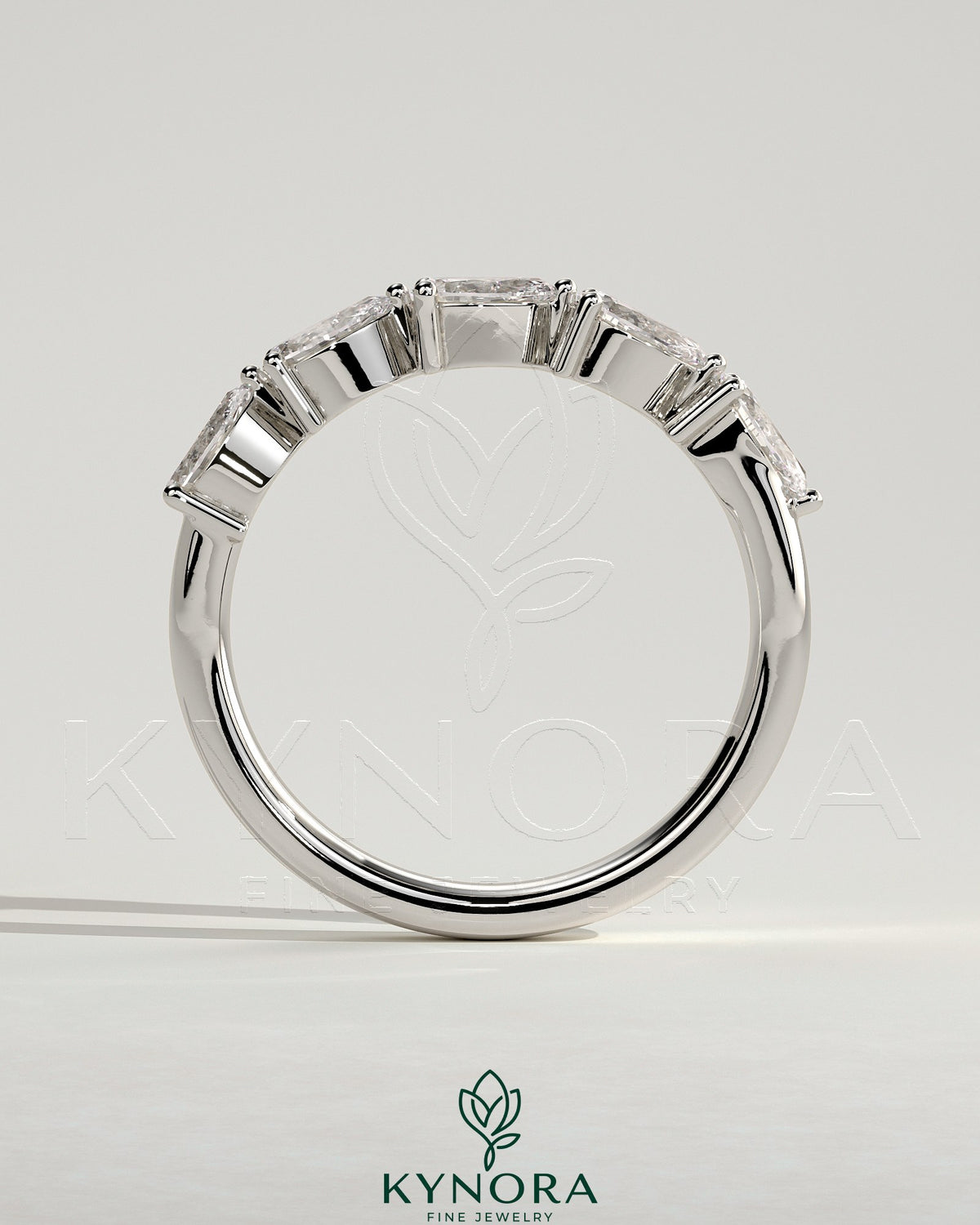 Kynora CJ Pear East West Accent Stone wedding band with closed basket setting, featuring a pear-shaped gemstone in elegant jewelry design.