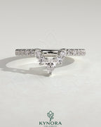 Pear-shaped accent stone with curved pave band wedding ring by Kynora CJ, featuring elegant design and sparkling details.