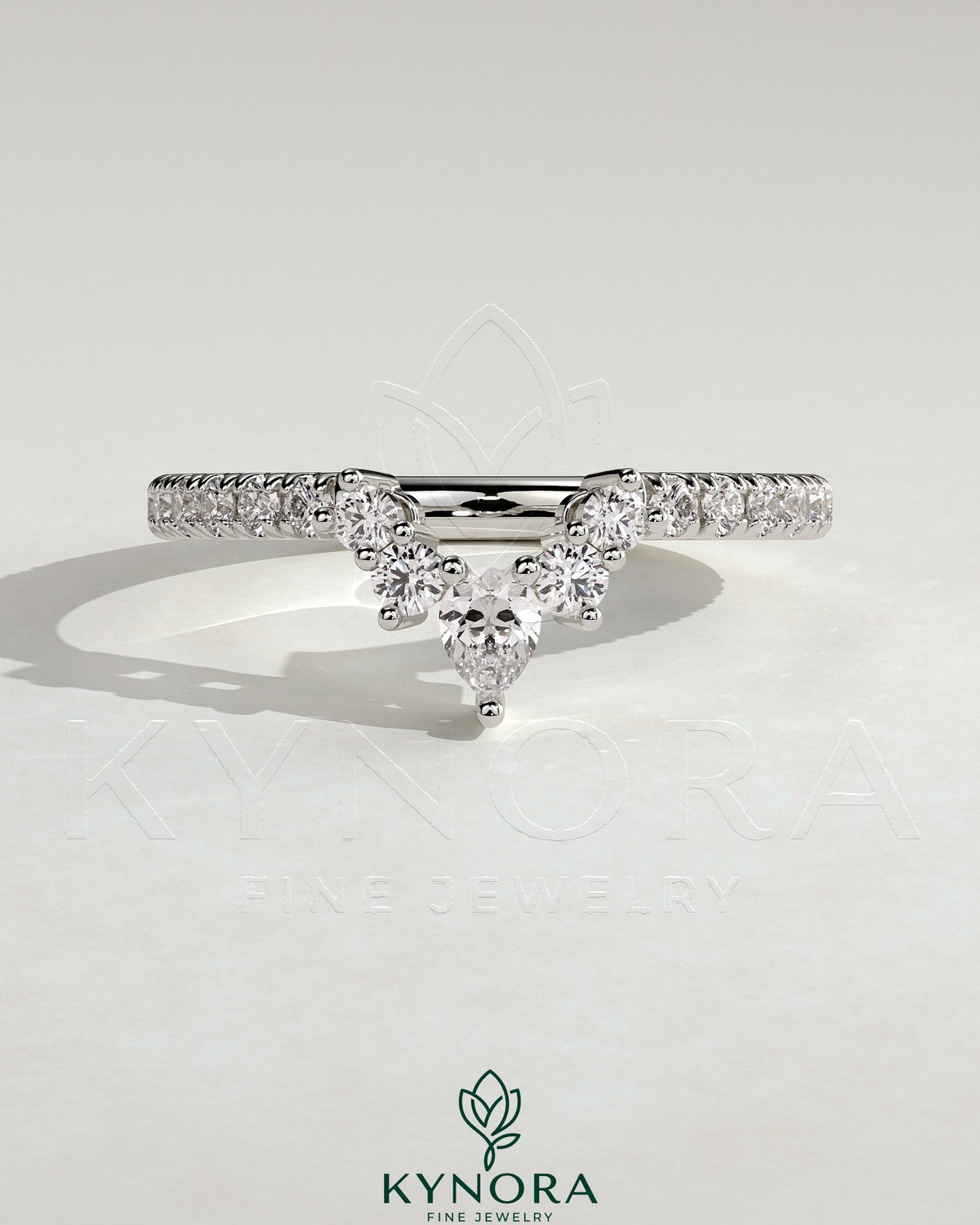 Pear-shaped accent stone with curved pave band wedding ring by Kynora CJ, featuring elegant design and sparkling details.