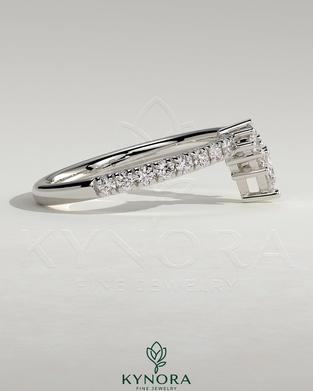 Pear-shaped accent stone with curved pave band wedding ring by Kynora CJ, showcasing elegant jewelry design.