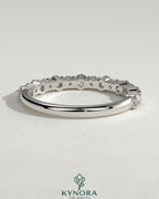 Round mixed size accent stone wedding band by Kynora CJ featuring a sleek, elegant design with alternating stones on a polished band.