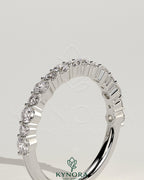 Kynora CJ round mixed size accent stone wedding band with various sized sparkling stones on silver-tone metal.