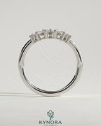 Kynora CJ round accent stone wedding band with curved design, showcasing polished gold finish and sparkling gemstone details.