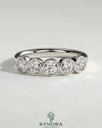 Kynora CJ round bezel set wedding band with a sleek, polished design, showcasing a smooth, circular bezel setting on the gold ring.