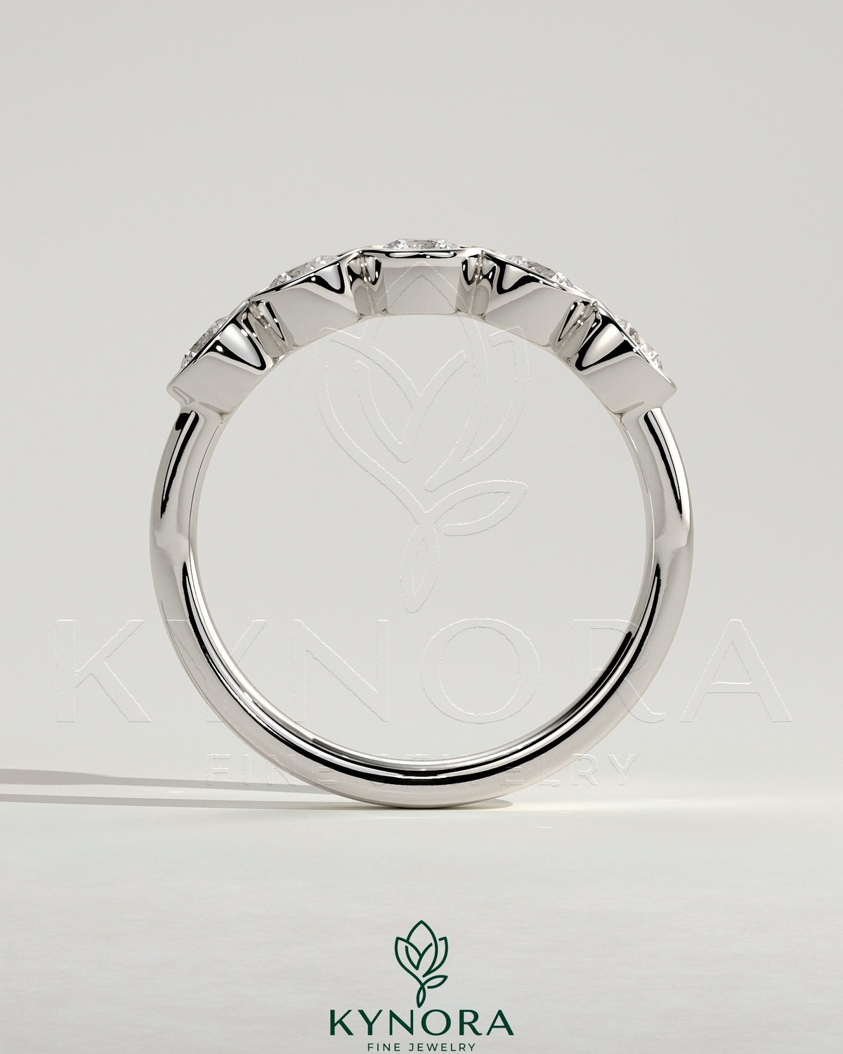 Round bezel set wedding ring by Kynora CJ, elegant wedding band with a smooth, polished finish and a central gemstone setting.