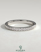 Kynora CJ round channel set wedding band with a sleek, polished design featuring embedded gemstones on a silver band.