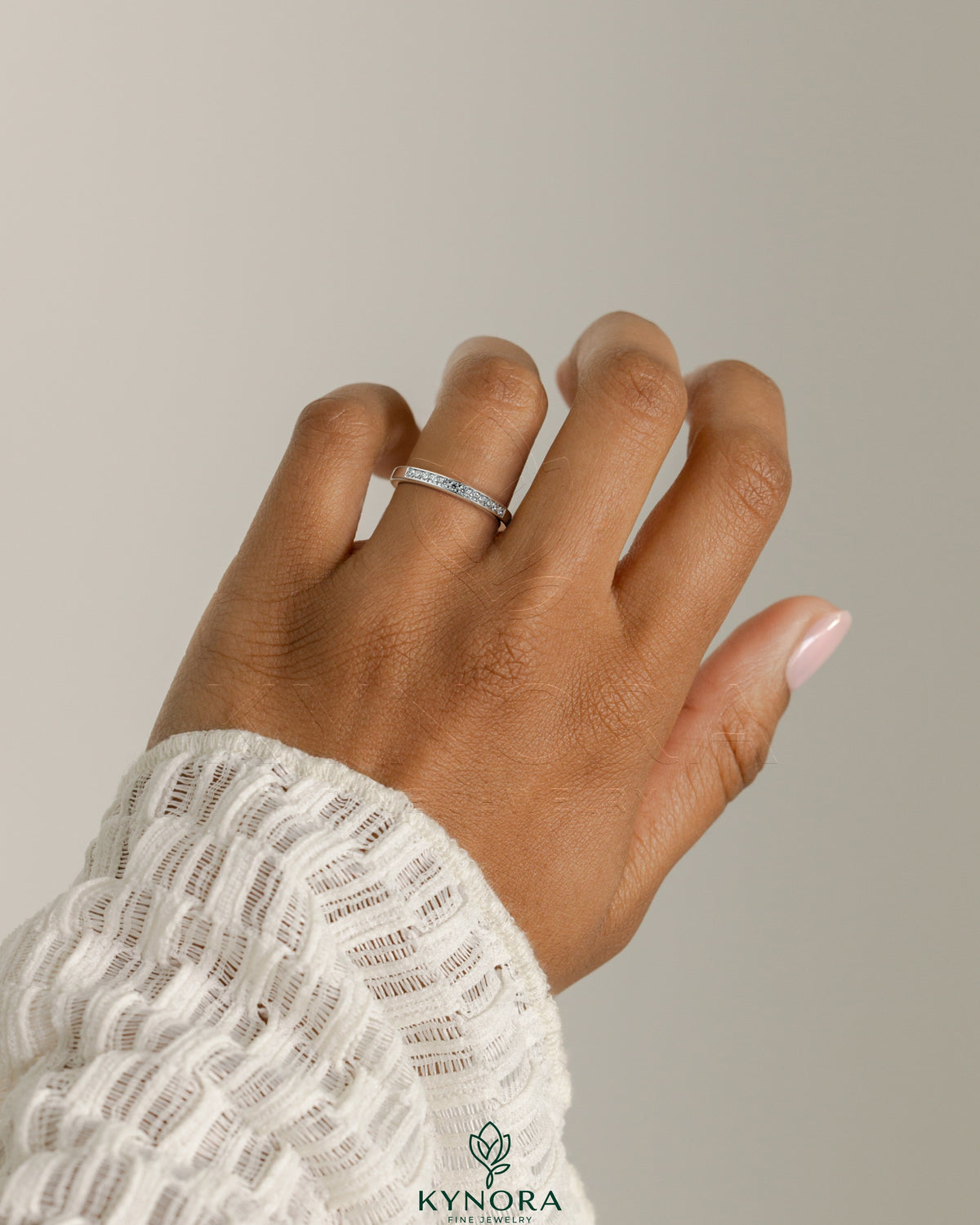 Kynora CJ round channel set wedding band with a sleek, polished design featuring embedded gemstones on a silver band
