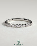 Round shared prong accent stone wedding ring by Kynora CJ, featuring a sleek band with sparkling accent stones.