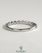 Round shared prong accent stone wedding ring by Kynora CJ, featuring a polished band with sparkling accent stones.