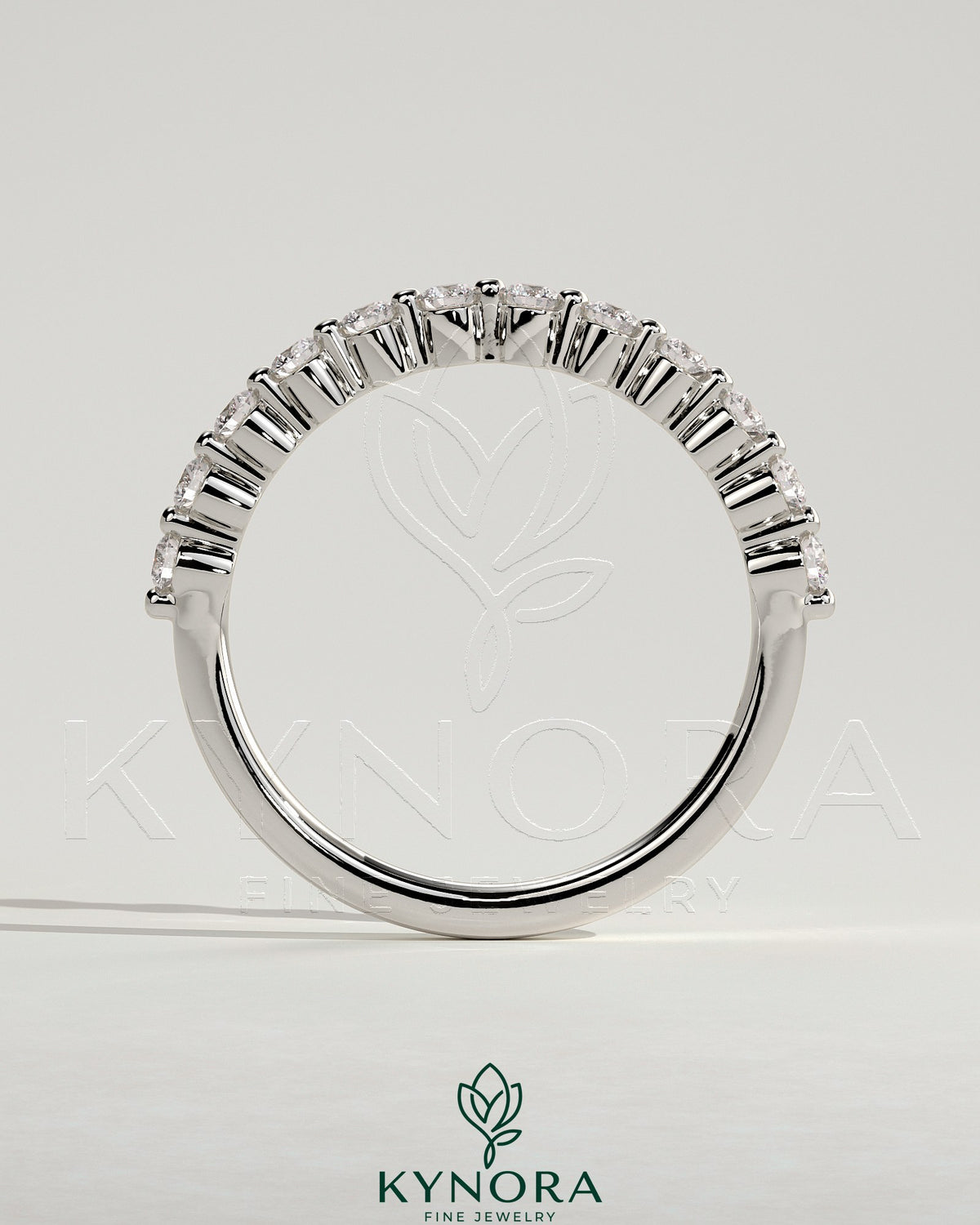 Round shared prong accent stone wedding ring by Kynora CJ featuring sparkling stones and a sleek band design.