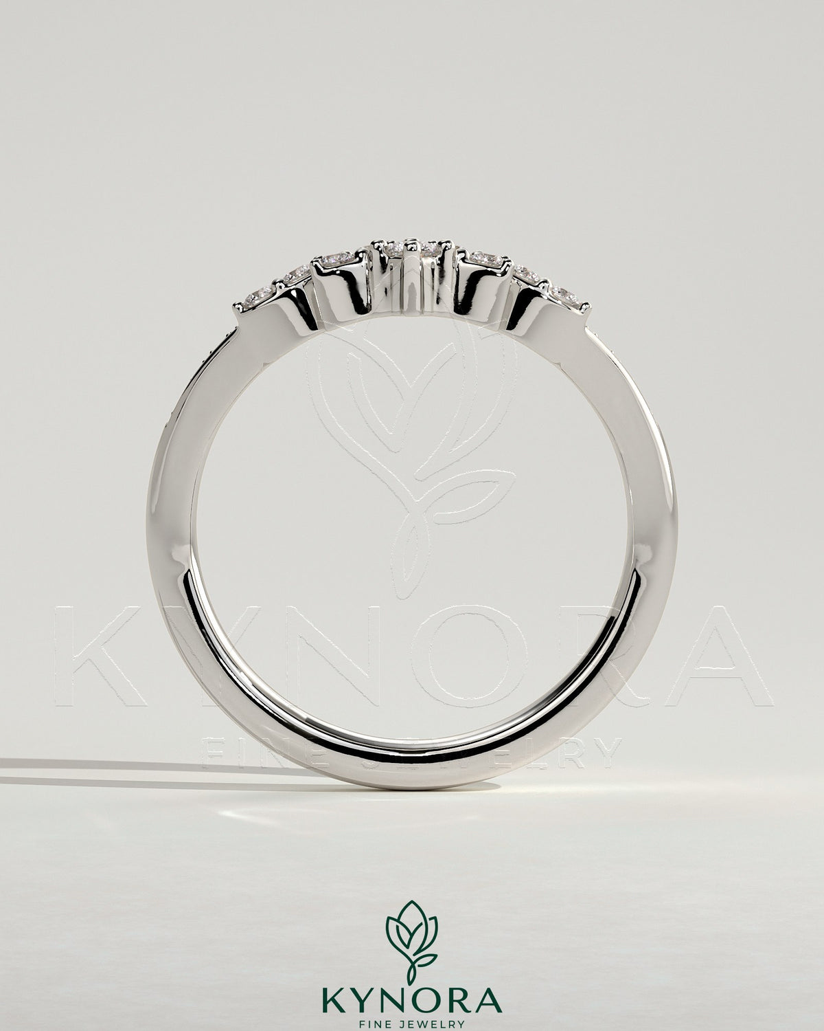 Close-up of Kynora CJ studded tiara curved pave band wedding ring with sparkling stones on a silver band.