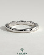 Elegant twisted band wedding ring by Kynora CJ featuring a sleek, intertwined design in polished metal.