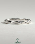 Kynora CJ twisted band wedding ring in polished metal with a braided design, showcasing elegant craftsmanship.