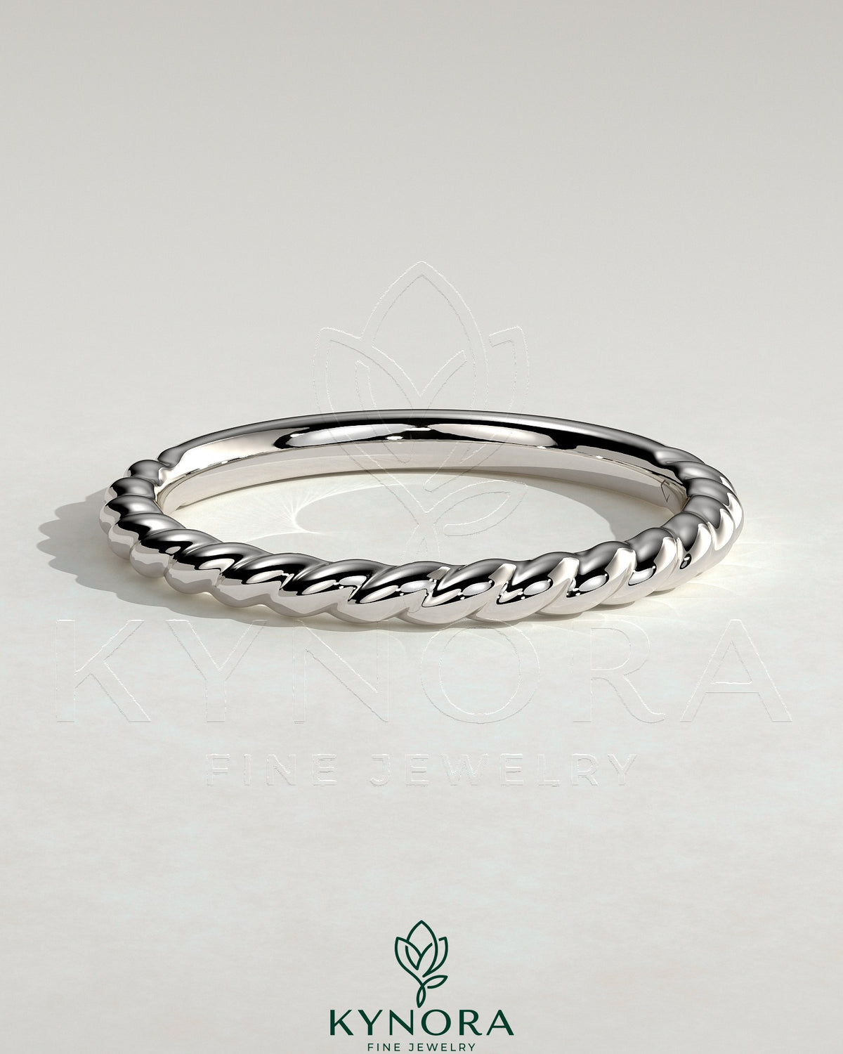 Elegant woven band wedding ring by Kynora CJ with intricate braided design in polished metal, perfect for bridal jewelry.
