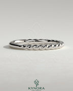 Kynora CJ woven band wedding ring with intricate woven design, made of polished metal, showcasing elegant craftsmanship.