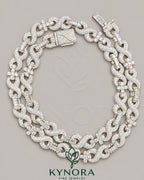 VVS Moissanite diamond infinity and cross pendant on 10mm silver Cuban chain by Kynora Jewels, showcasing intricate design and sparkling stones.