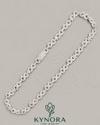 Kynora Jewels 10mm VVS Moissanite diamond infinity and cross pendant on silver Cuban chain, hip-hop jewelry style.