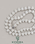 Heart-shaped sterling silver tennis link chain with 7mm VVS1 moissanite diamond halo, hip-hop style from Kynora Jewels.