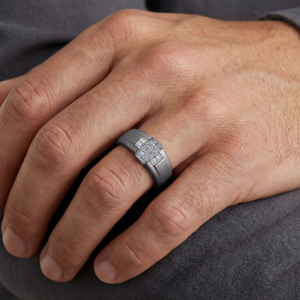 Men's titanium ring featuring a 10k yellow gold and moissanite pave cross design, showcasing detailed craftsmanship and sparkling stones